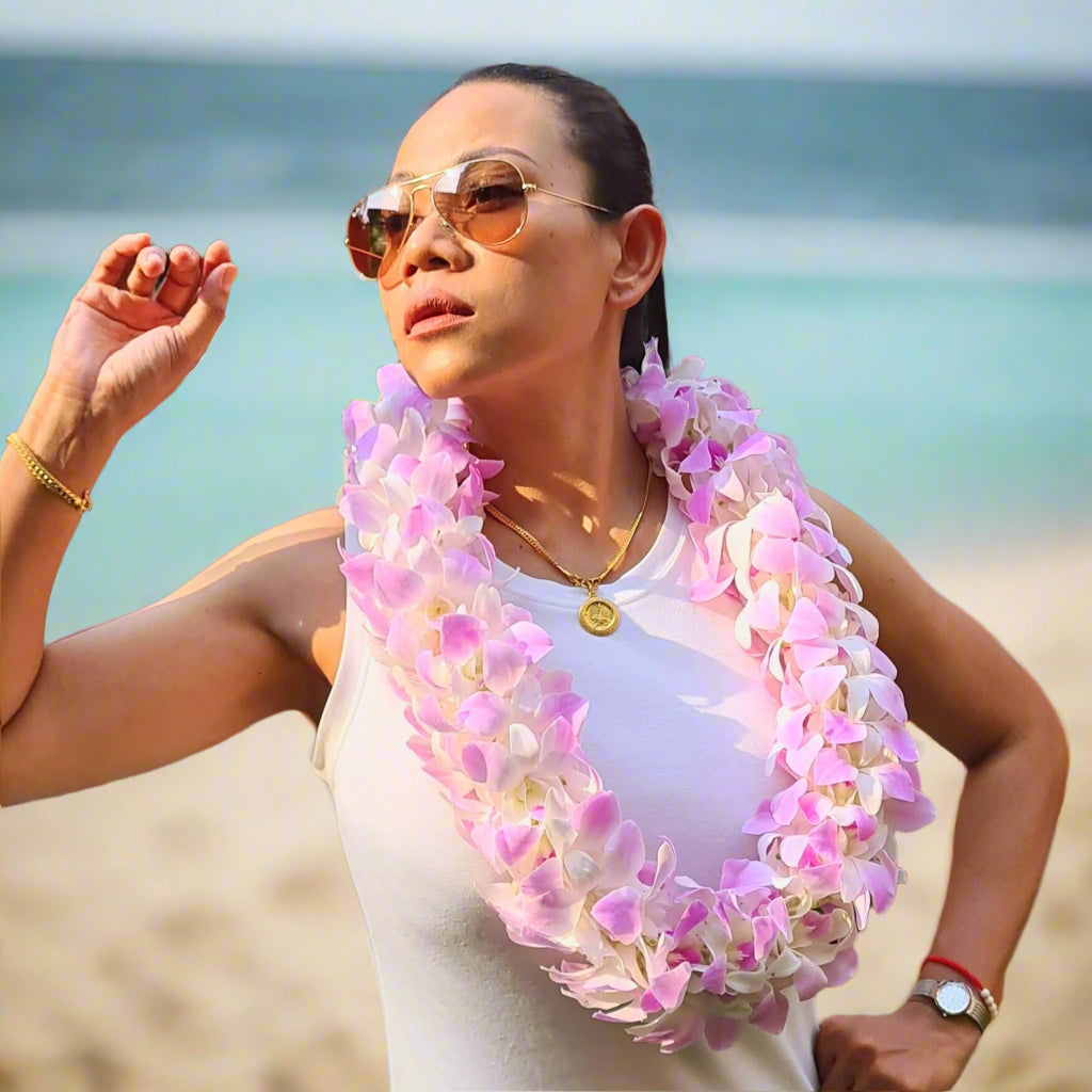 The Pink Blush Lei is a double orchid lei handcrafted with over 100 fresh pink and white orchid blooms. This graceful floral accessory is perfect for Hawaiian-themed parties, beach weddings, and graduations, adding a touch of elegance to any occasion. The soft hues create a romantic and sophisticated look, making it a standout piece for any celebration