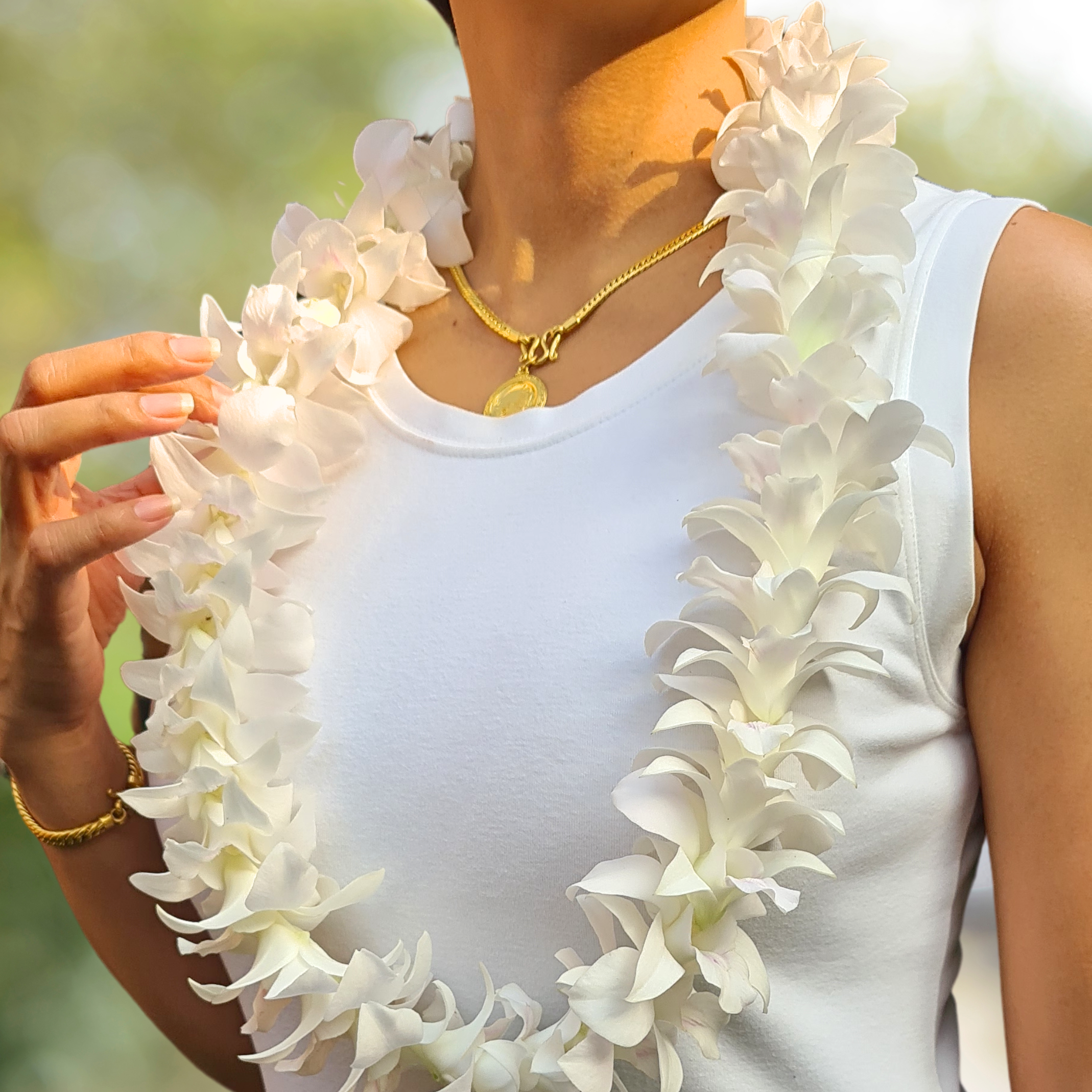 Elegant white orchid lei made with fresh Dendrobium orchids, perfect for weddings, beach parties, graduations, and tropical-themed events. Handcrafted in Thailand, this lei is a striking addition to luaus, poolside events, and BBQs